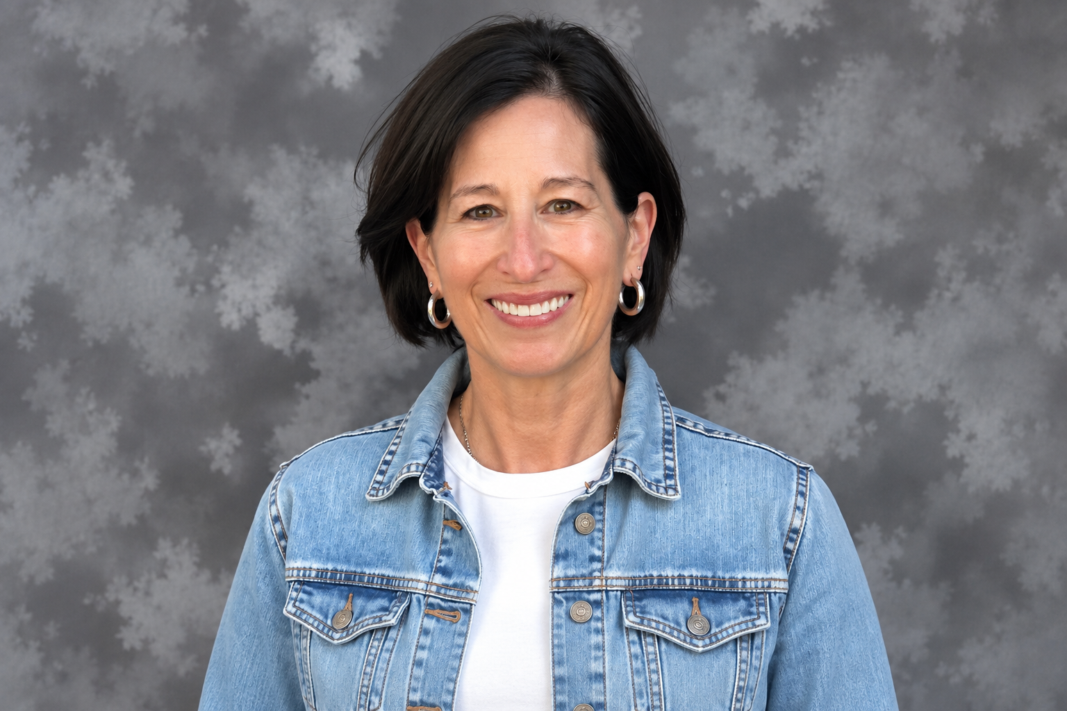 Julie Hess, smiling in a denim jacket